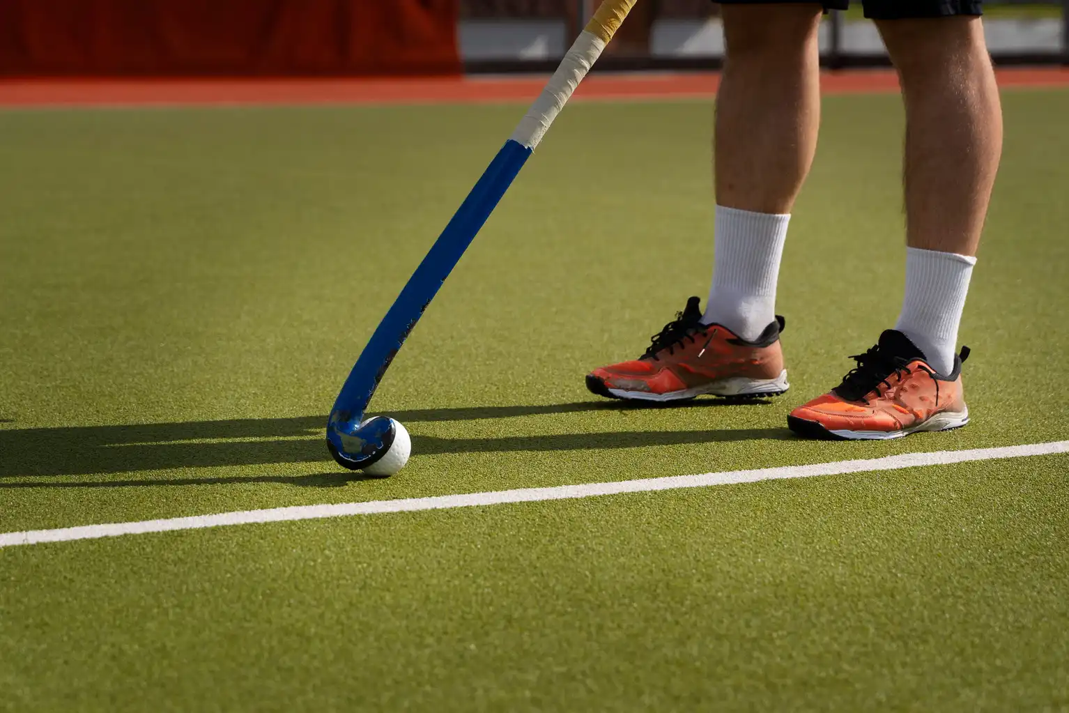 Field hockey player driving the ball during a competitive night game