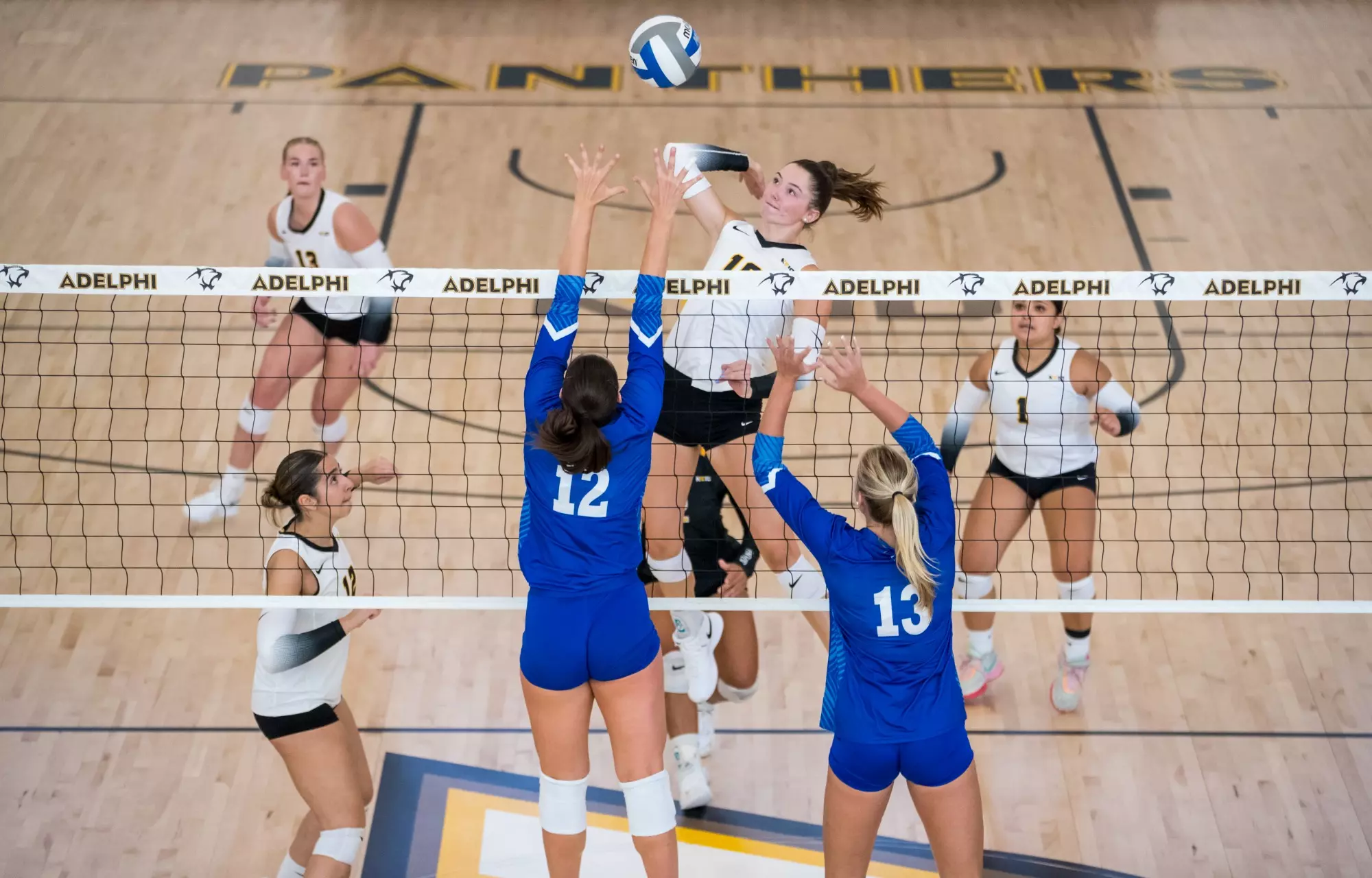 Mackenzie Casey of Adelphi University spiking the ball at the net