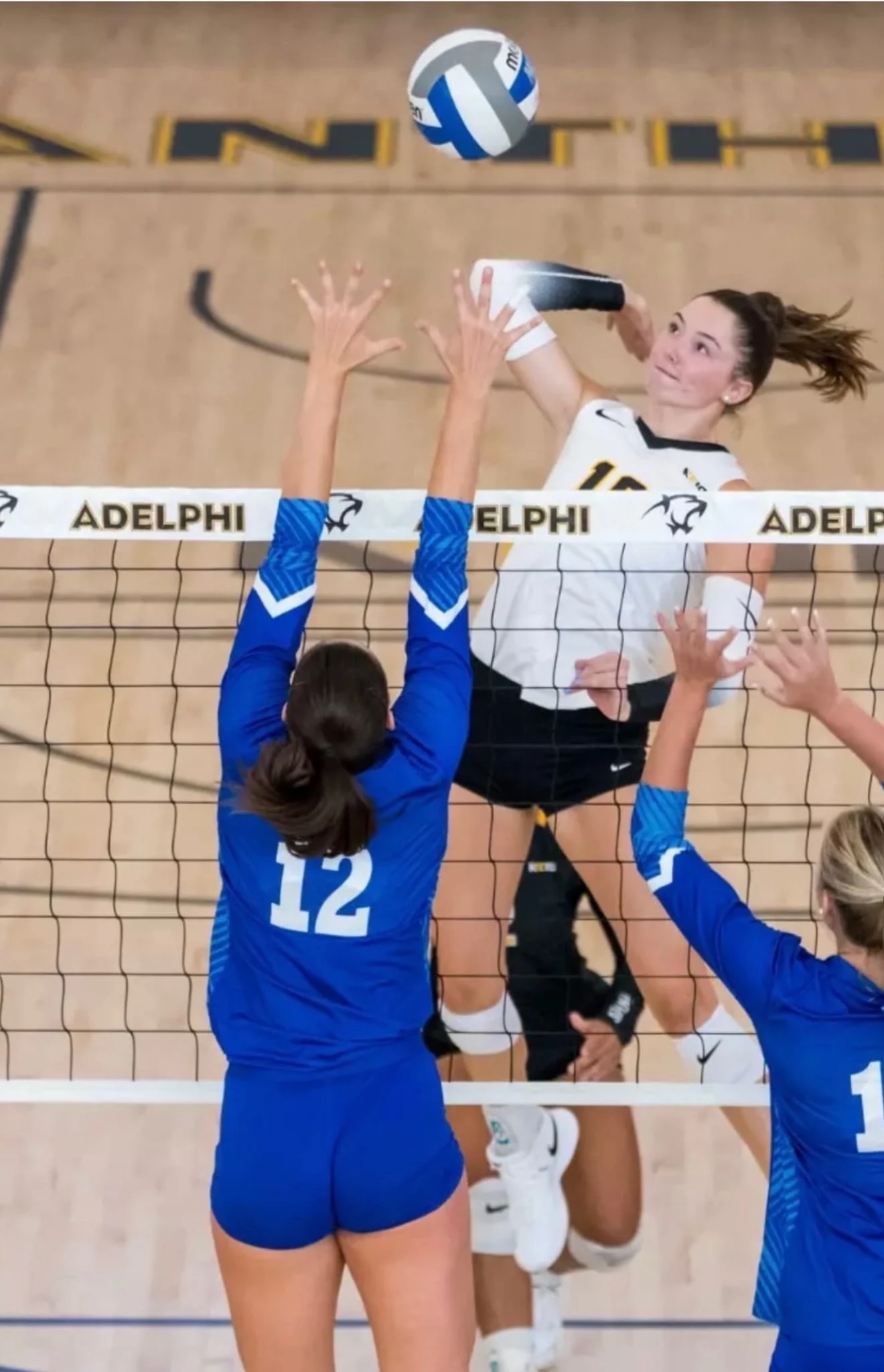 Mackenzie Casey of Adelphi University spiking the ball