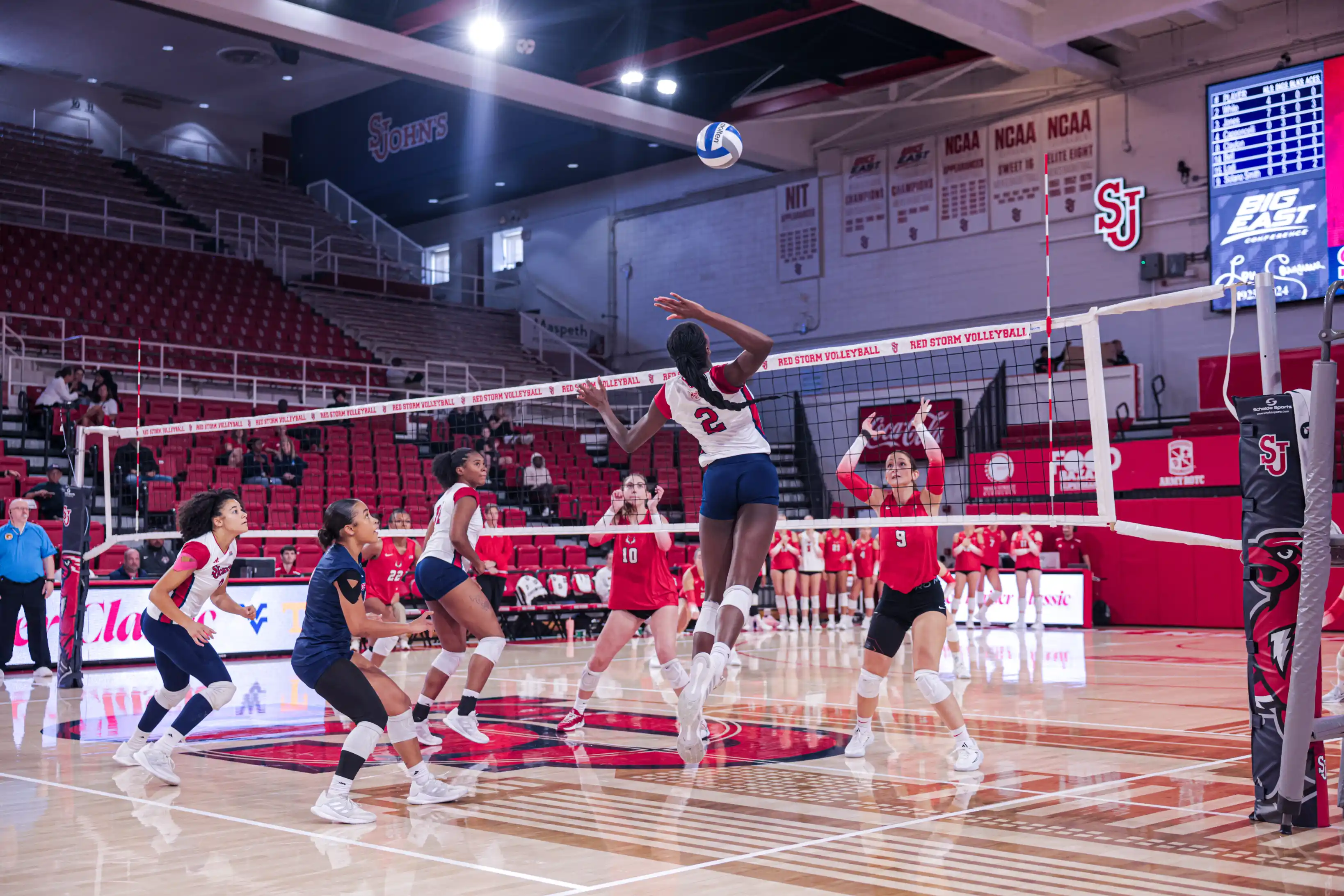 Volleyball player spiking during a collegiate match at St. John's University